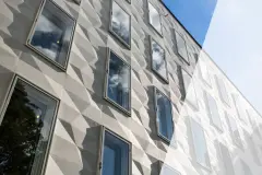 Gedämmte Hausfassade mit Fenstern, gestaltet mit dreidimensionalen Fassadenelementen – hier: StoDeco